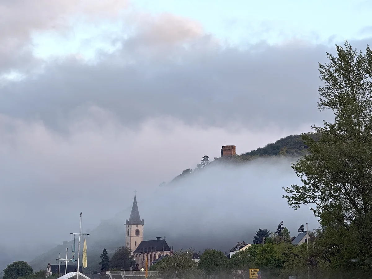 Schlafzimmer mit Doppelbett, weißer Bettwäsche und Fenster mit Blick auf das Wasser.