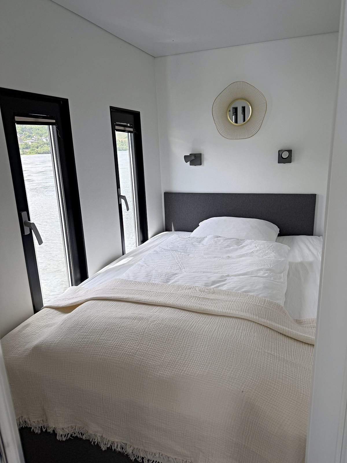 Zweites Schlafzimmer mit Doppelbett und Fenster zur Uferseite.