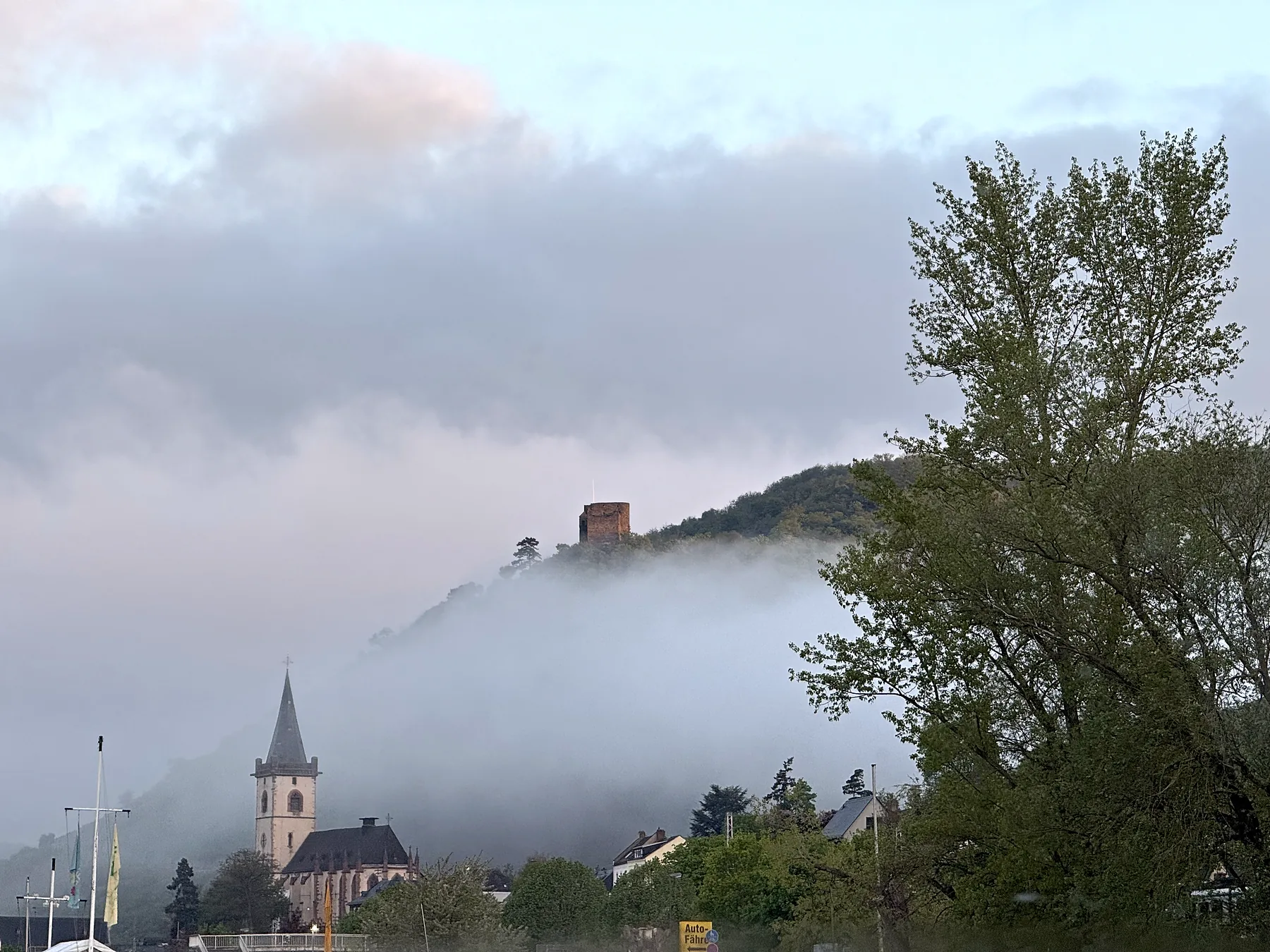 Offener Wohnraum mit weißer Küchenzeile, Esstisch und bodentiefen Fenstern zum Rhein.