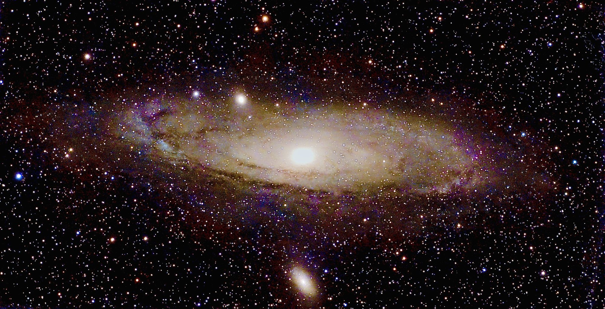 Die Andromedagalaxie M 31 als schräg stehende Spirale mit Staubbändern, daneben die Begleitgalaxien M 32 und M 110.