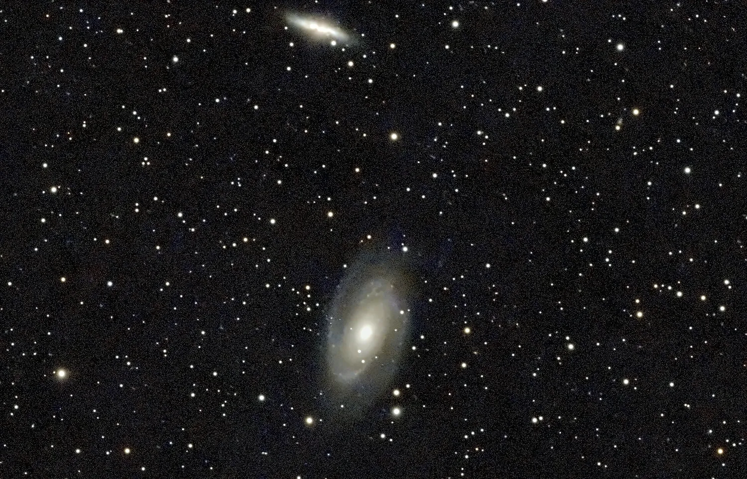 Das Galaxienpaar M 81 und M 82: unten die helle Spirale von Bodes Galaxie, darüber die schmale, hell aufleuchtende Zigarrengalaxie.