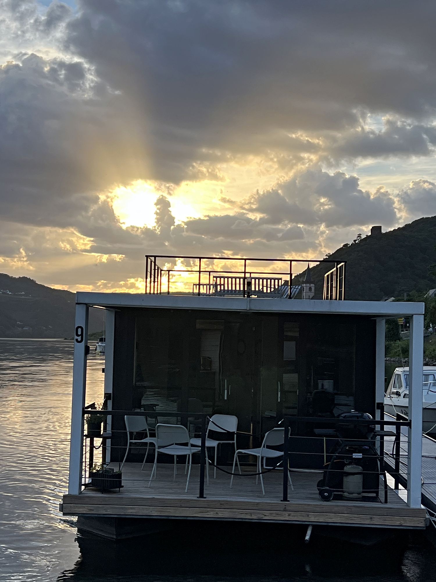 Sonnenstrahlen brechen durch die Wolken über der Dachterrasse.